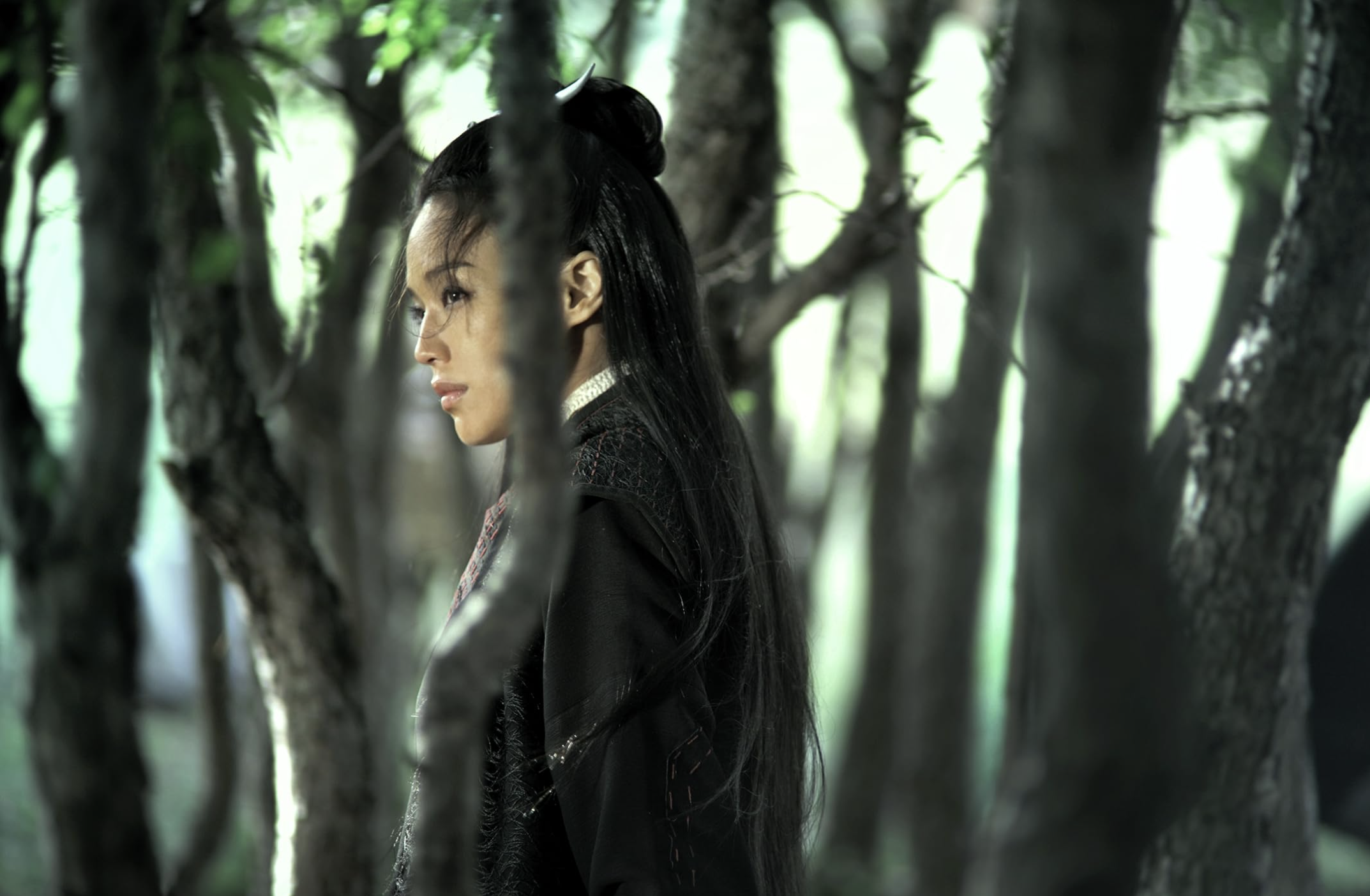 Still image from the film Assassin with the main character standing in a forest.